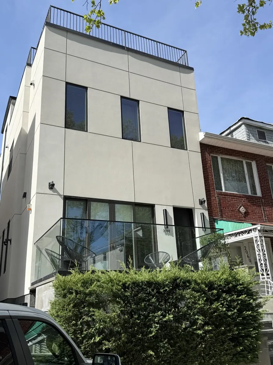 Brooklyn stucco facade divided into panels by recessed reveal lines