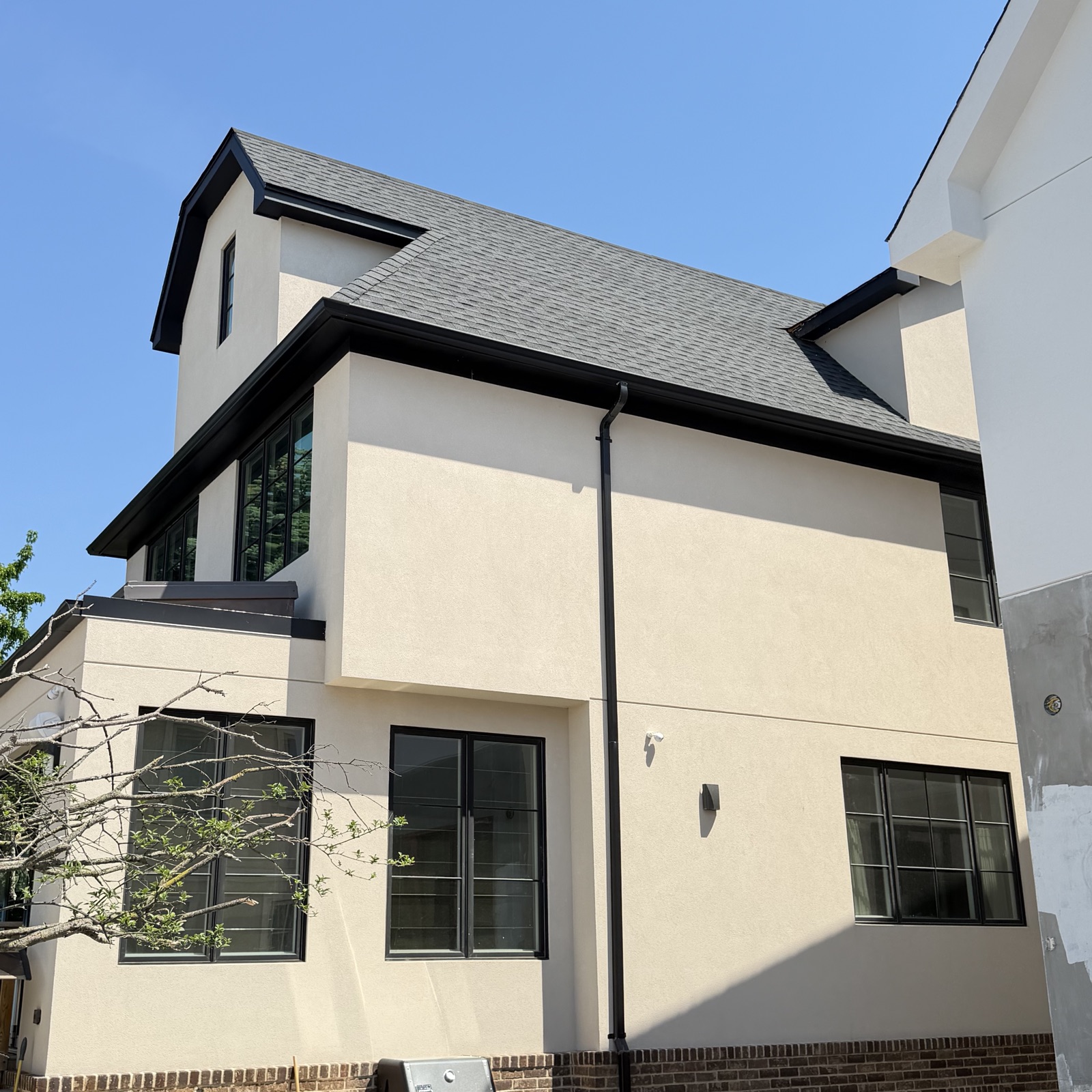 Roof to wall transition and downspout on a Brooklyn stucco house