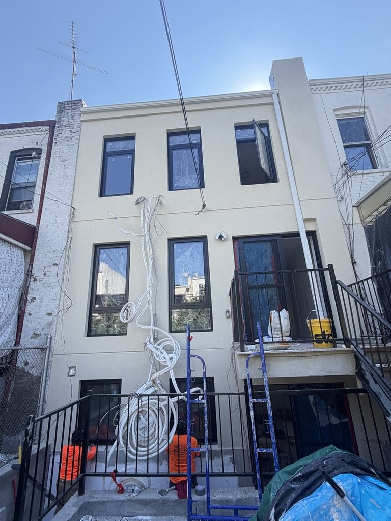 MNM crew finishing stucco on a three story rear facade in Brooklyn